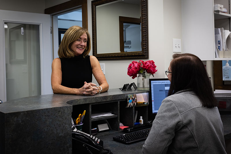Contact Seibert Complete Dentistry. Woman at front desk of cincinnati office.